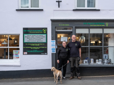 2 people and dog outside shop