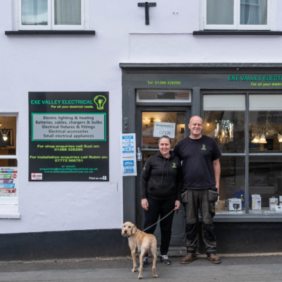 2 people and dog outside shop